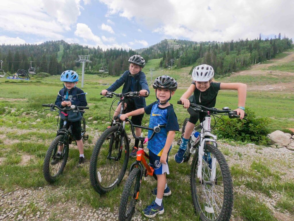 biking kids with helmets relaxing in a trail