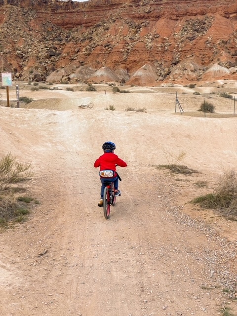 Little boy mountain biking in the desert