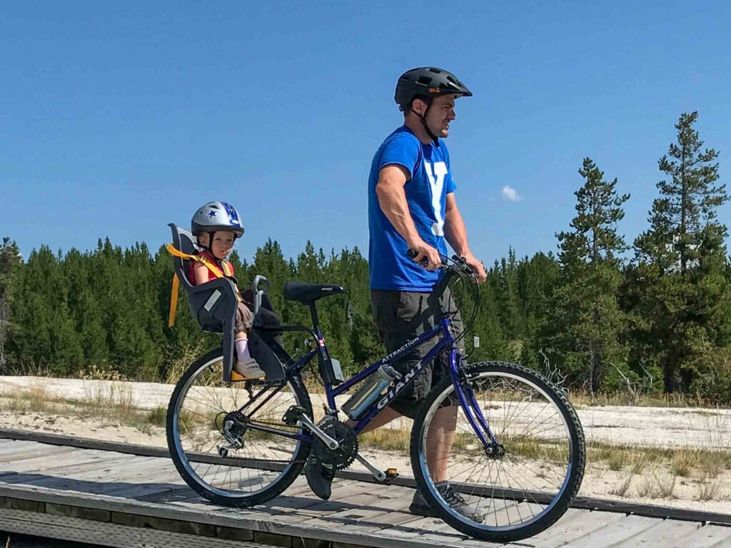 biking in yellowstone giant with a rear-mounted kids bike seat