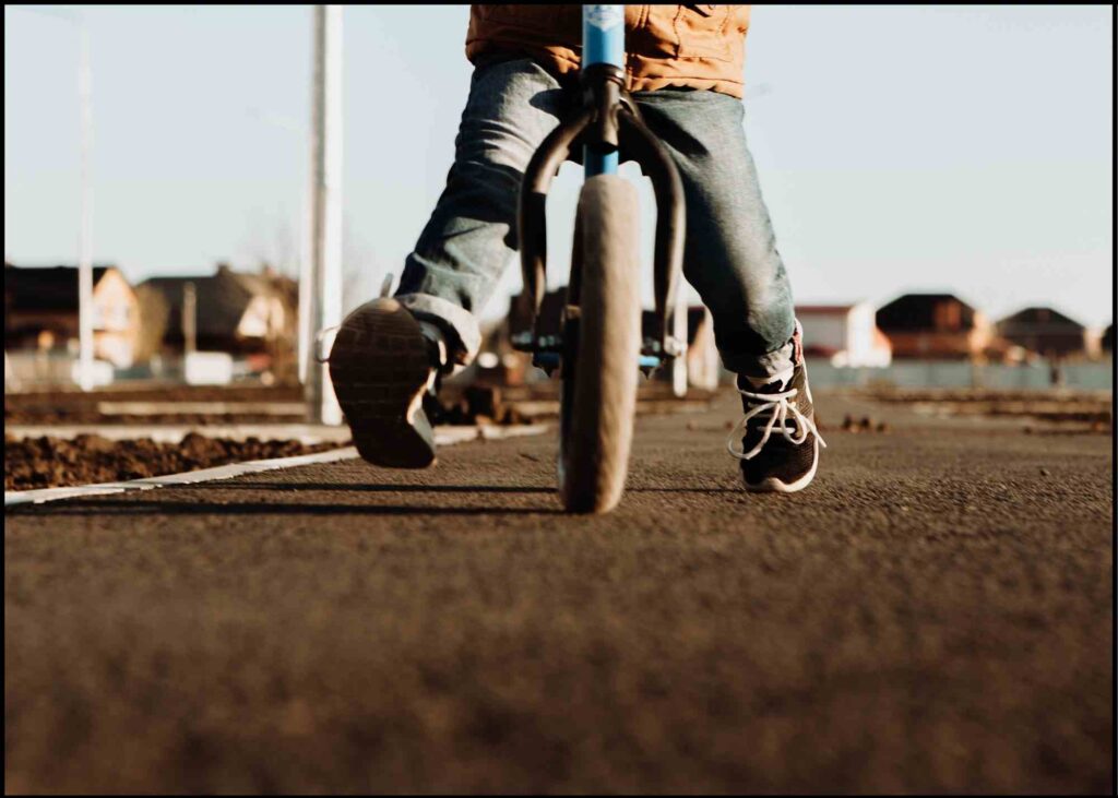 close up image of an older kid riding a balance bike for older kids